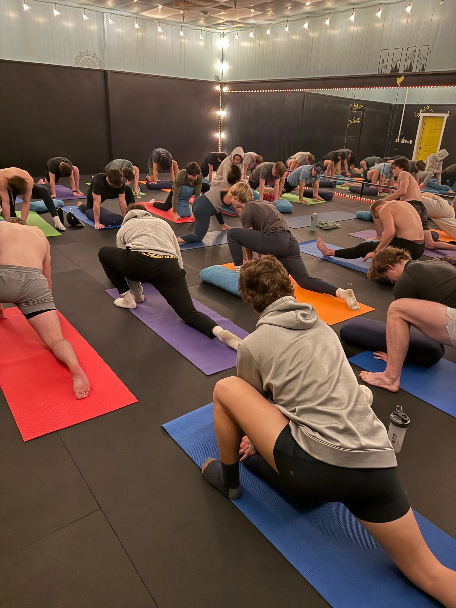 Players holding low lunges during a yoga session in the studio