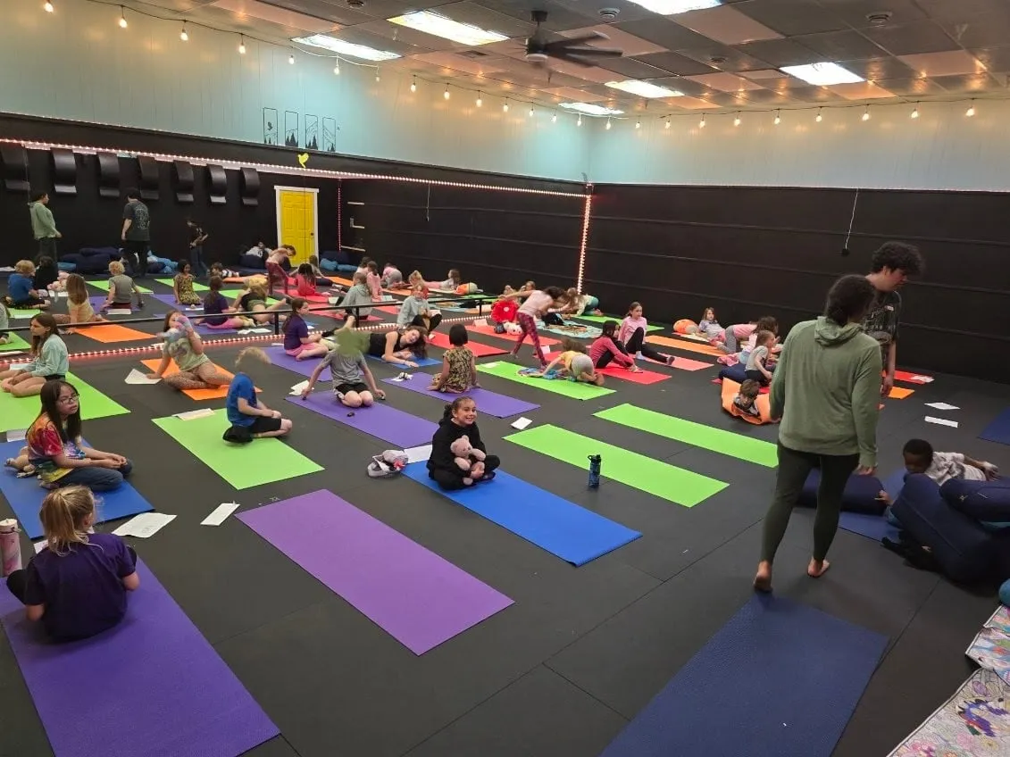 Kids on colorful mats during a yoga camp in the studio