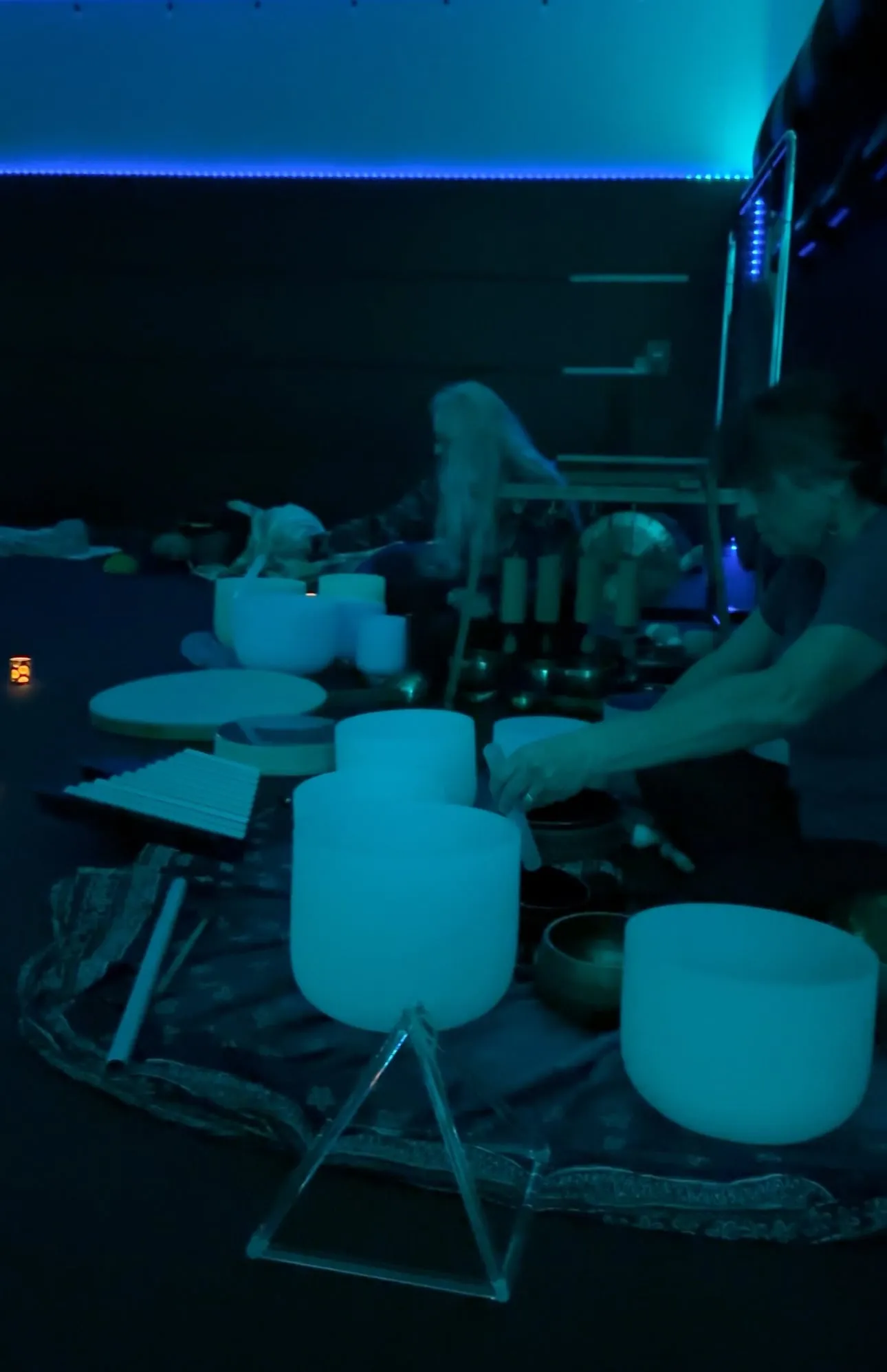 Crystal singing bowls glowing under blue light