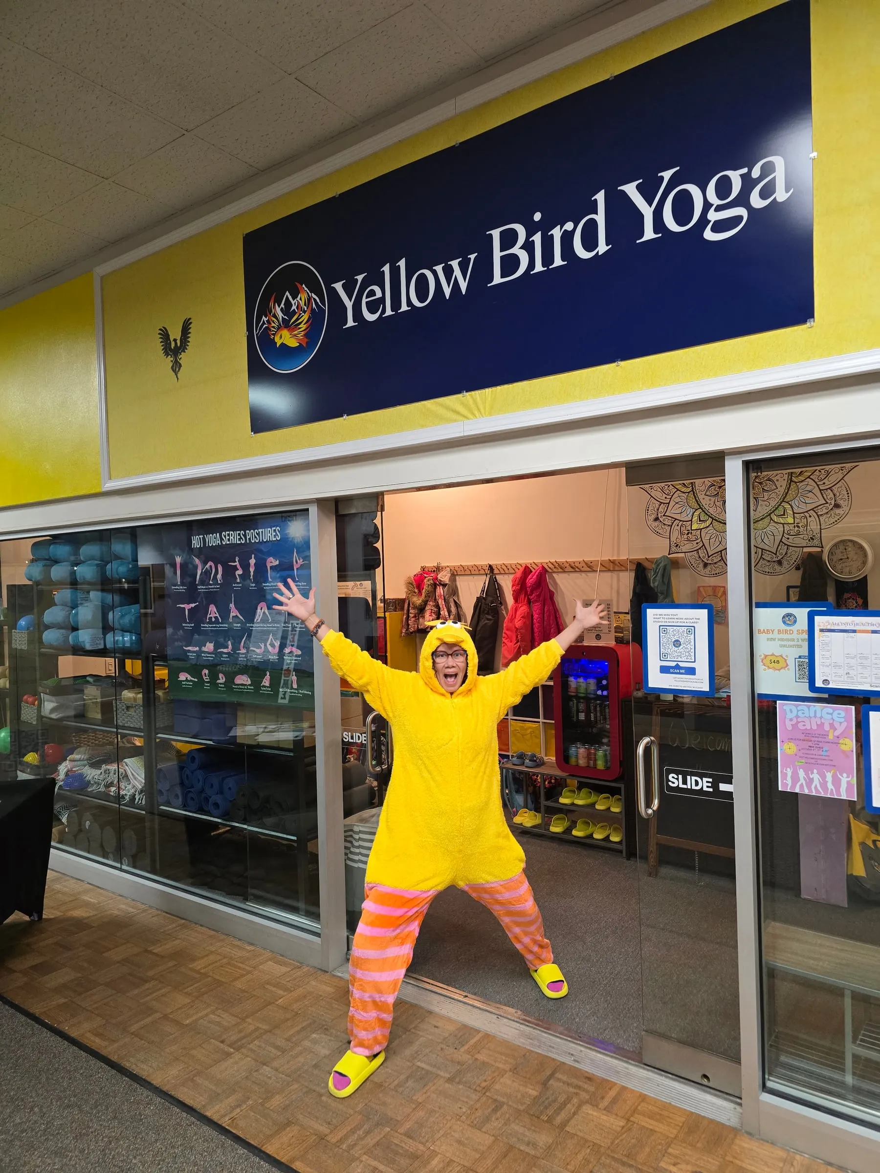 Someone in a yellow bird costume cheering at the studio entrance