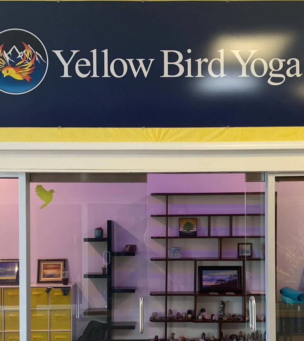 The Yellow Bird Yoga storefront sign